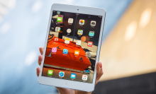 iPad mini 2 being held up in someone's hand.