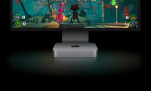 The Apple Mac mini resting below a larger Apple-brand monitor
