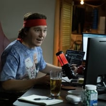Paul Dano as RoaringKitty, a young white man in front of a home computer and microphone setup.