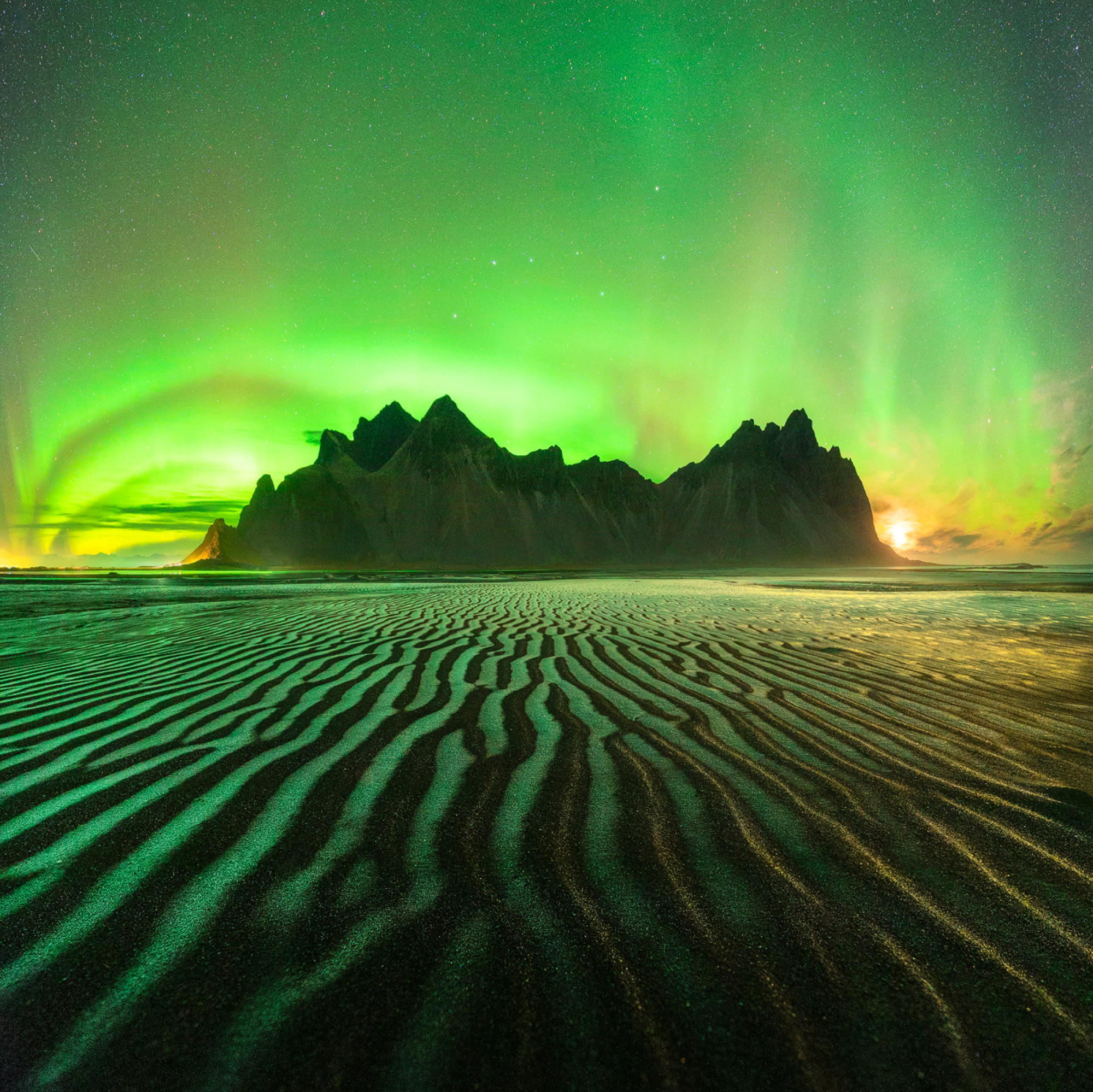 An image of the green Northern Lights over a mountain range.