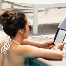 woman reading on kindle in a pool